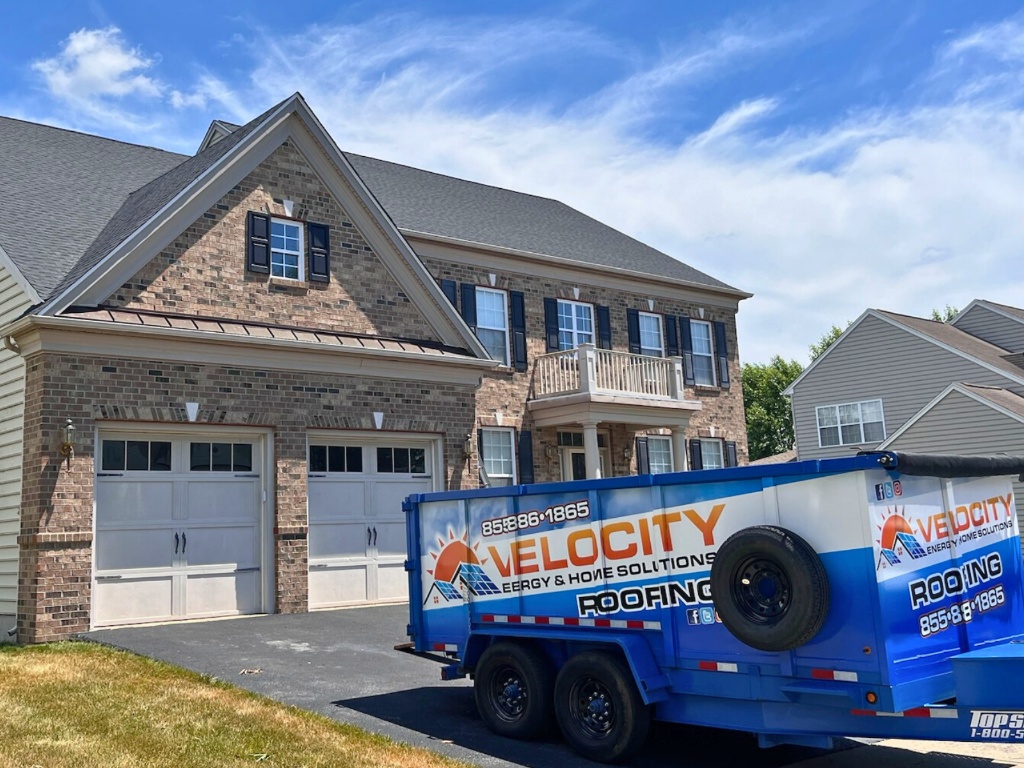 Large brick and stone two-story home with Velocity trailer in driveway